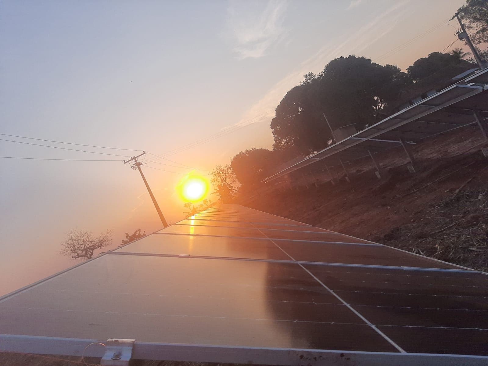 Módulos fotovoltaicos ao pôr do sol em instalação da Agiliza