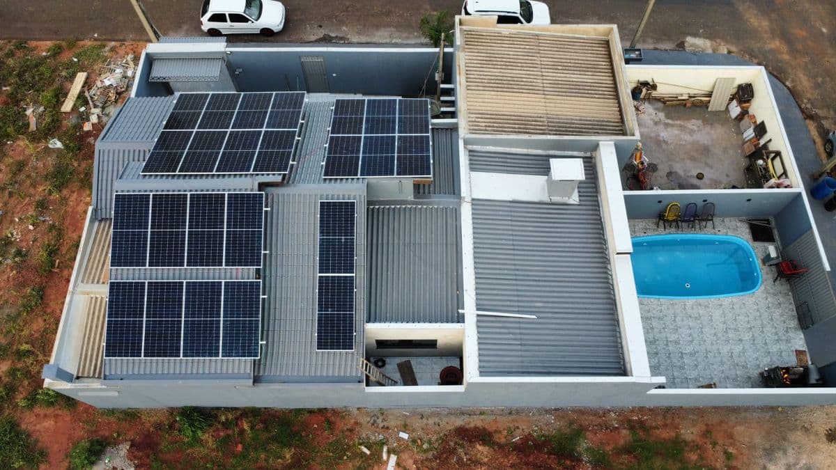 Vista aérea de residência com módulos fotovoltaicos instalados na laje